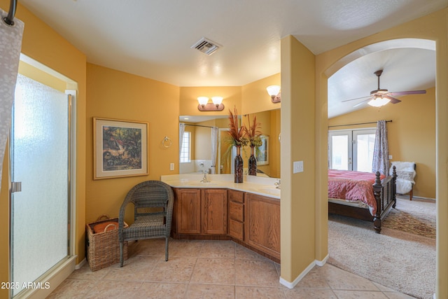 ensuite bathroom featuring tile patterned floors, visible vents, double vanity, and a sink