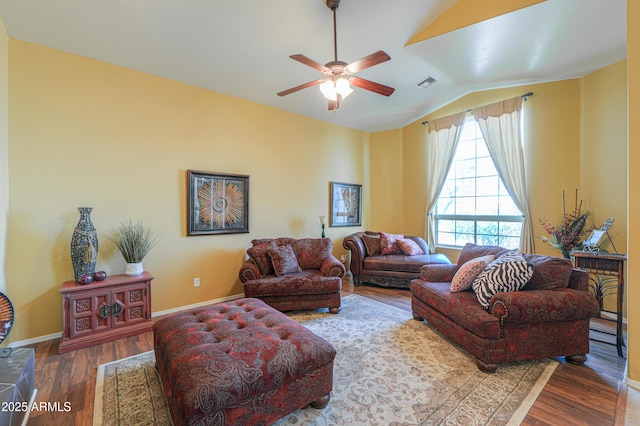 living area featuring visible vents, a ceiling fan, wood finished floors, baseboards, and lofted ceiling