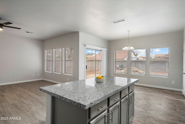 10551 W Jessie Ln, Peoria, AZ 85383 - kitchen featuring gray cabinets, baseboards, light wood-style floors, and visible vents