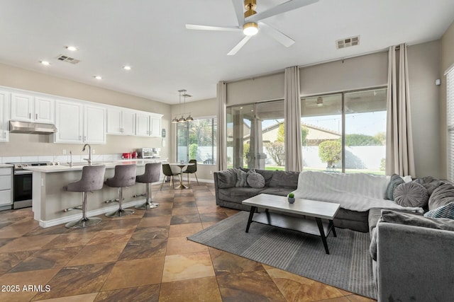 living room featuring sink and ceiling fan