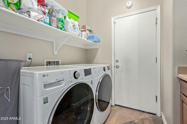 clothes washing area with washing machine and clothes dryer and light tile patterned floors