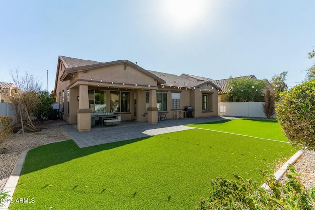 rear view of house featuring a yard and a patio