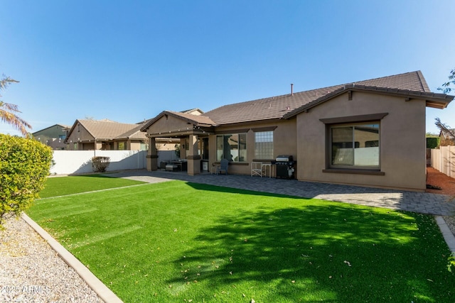 rear view of property featuring a yard and a patio area