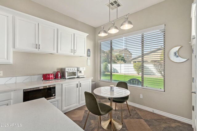 kitchen featuring white cabinets and decorative light fixtures