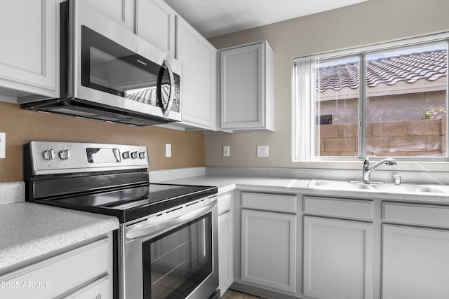 6410 W Winslow Ave, Phoenix, AZ 85043 - kitchen featuring appliances with stainless steel finishes, a sink, light countertops, and white cabinets