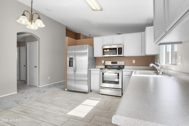 6410 W Winslow Ave, Phoenix, AZ 85043 - kitchen with appliances with stainless steel finishes, arched walkways, a sink, light countertops, and vaulted ceiling