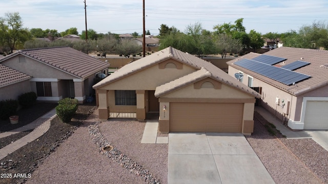 6410 W Winslow Ave, Phoenix, AZ 85043 - view of front of property featuring driveway, a garage, stucco siding, and solar panels