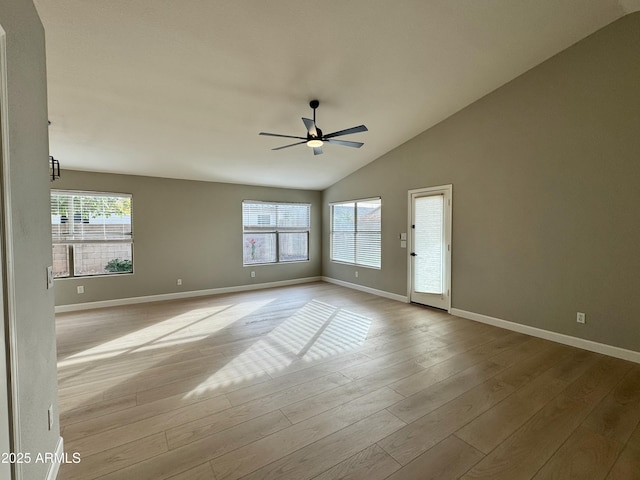 empty room featuring light hardwood / wood-style flooring, vaulted ceiling, and ceiling fan