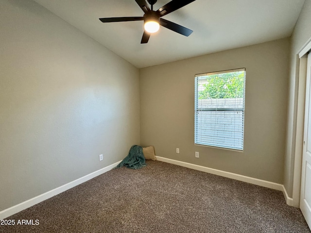 carpeted spare room with ceiling fan