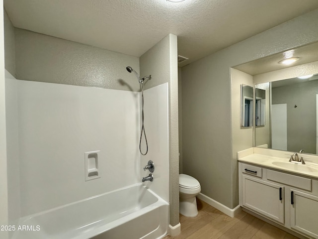 full bathroom featuring hardwood / wood-style floors, a textured ceiling, toilet, vanity, and shower / bathtub combination