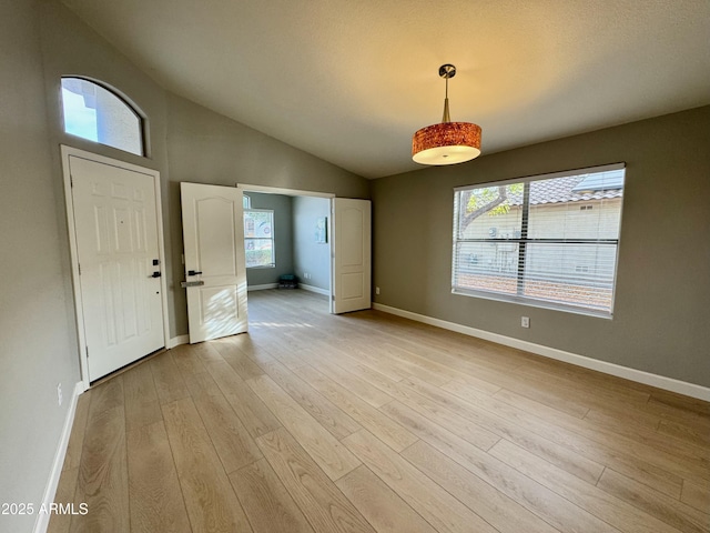 entrance foyer with light hardwood / wood-style flooring, plenty of natural light, and lofted ceiling