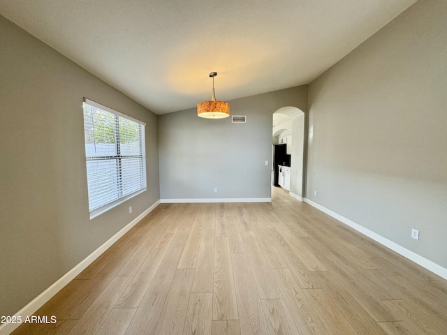 unfurnished dining area with lofted ceiling and light hardwood / wood-style flooring