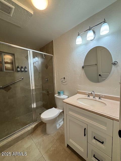 1940 E Indianola Ave E, Phoenix, AZ 85016 - bathroom with a textured wall, vanity, a stall shower, and tile patterned floors
