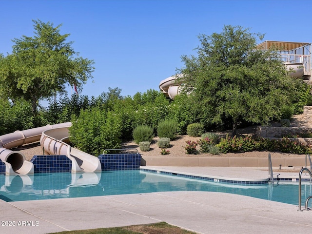 view of swimming pool with a water slide and a patio area