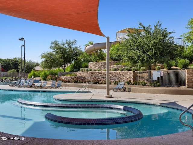 view of swimming pool featuring a hot tub and a patio