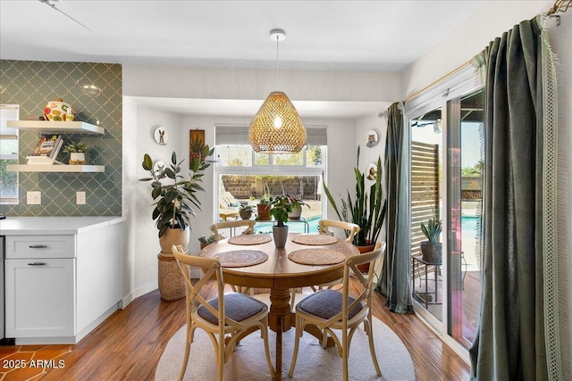 dining room featuring plenty of natural light, baseboards, and wood finished floors