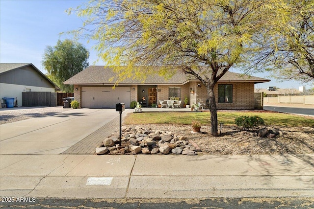 ranch-style house featuring driveway, an attached garage, and fence