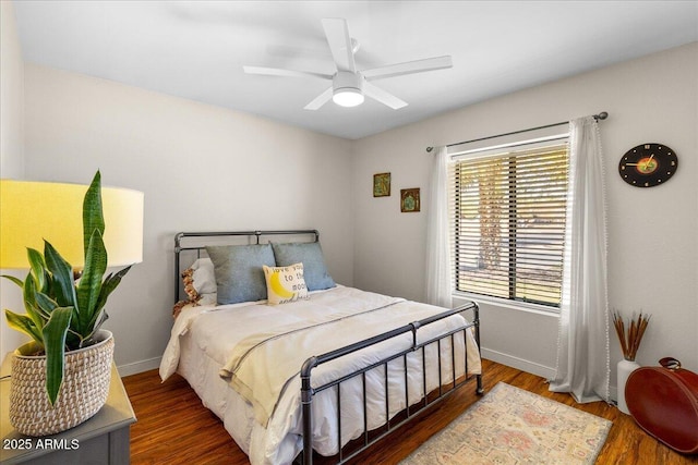 bedroom with ceiling fan, baseboards, and wood finished floors