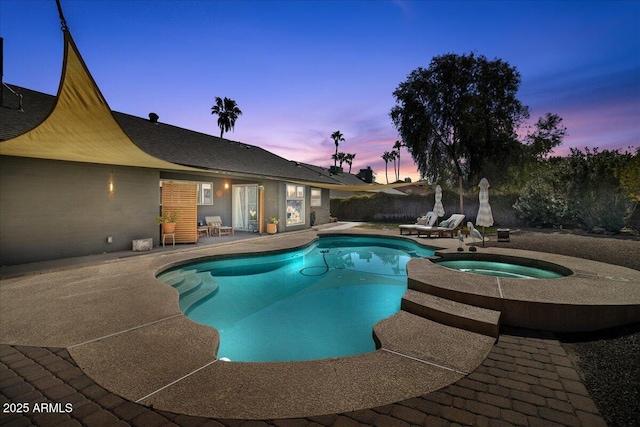 view of pool with a patio, fence, and a pool with connected hot tub