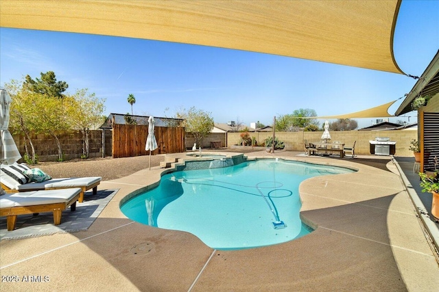 view of pool featuring a patio area, a fenced backyard, and a pool with connected hot tub