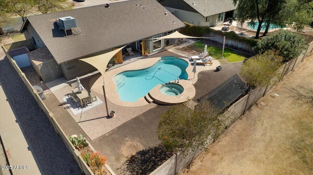 view of swimming pool featuring a pool with connected hot tub, a fenced backyard, and a patio