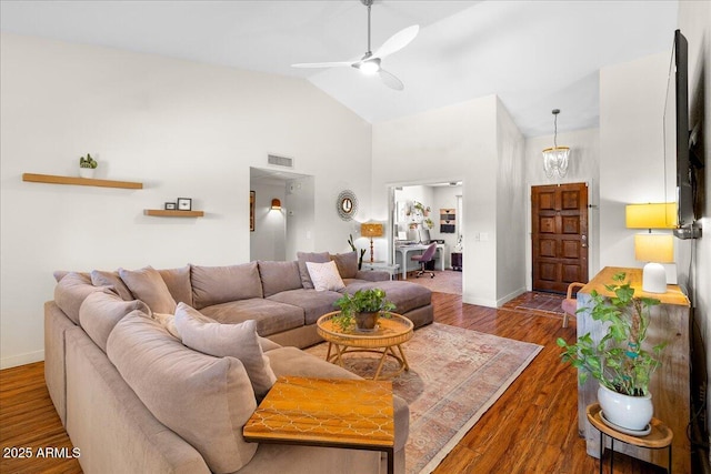 living area featuring visible vents, a ceiling fan, wood finished floors, high vaulted ceiling, and baseboards