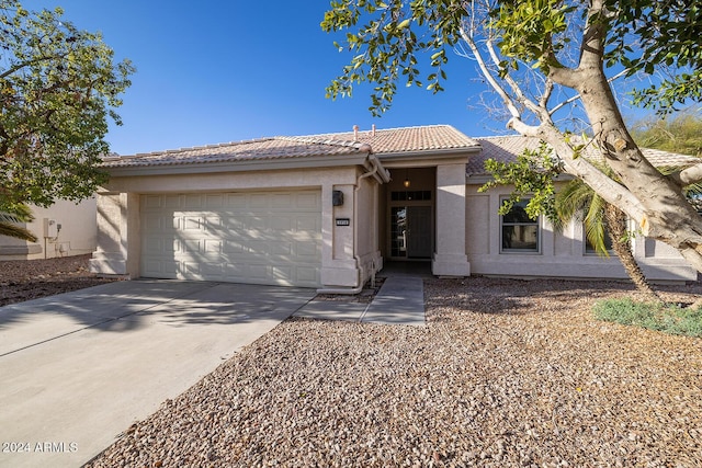 3956 N 151st Dr, Goodyear, AZ 85395 - view of front facade featuring a tile roof, a garage, stucco siding, and driveway