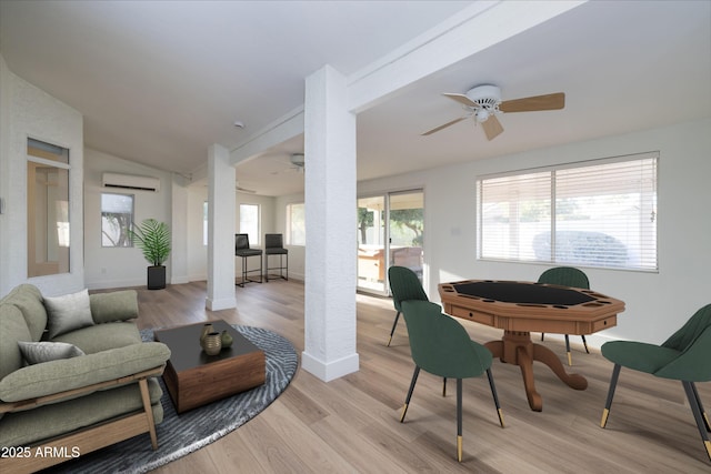 3956 N 151st Dr, Goodyear, AZ 85395 - living room featuring a ceiling fan, vaulted ceiling, a wall mounted AC, and light wood-type flooring