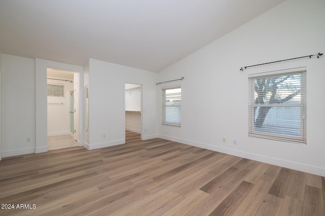 3956 N 151st Dr, Goodyear, AZ 85395 - unfurnished bedroom featuring a spacious closet, light wood finished floors, lofted ceiling, and a closet