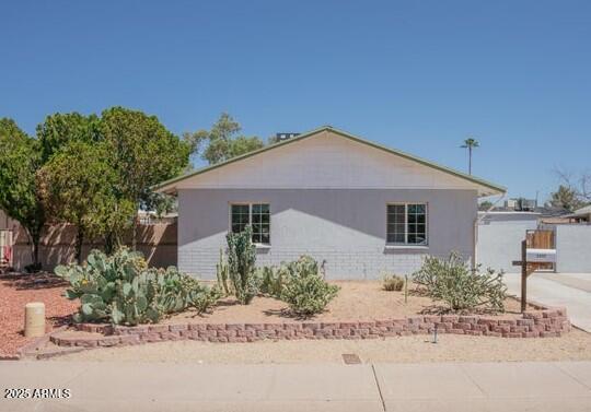 view of home's exterior with fence and concrete driveway