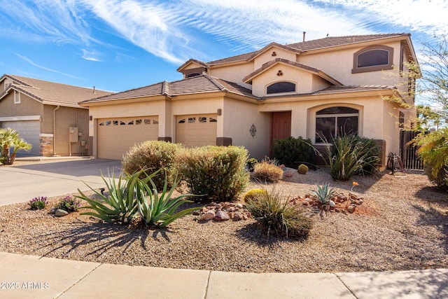 mediterranean / spanish home with driveway, an attached garage, and stucco siding