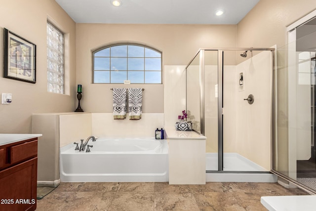 bathroom with recessed lighting, a garden tub, a shower stall, and vanity