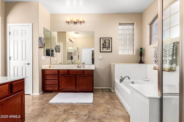 full bathroom featuring a garden tub, baseboards, visible vents, and vanity