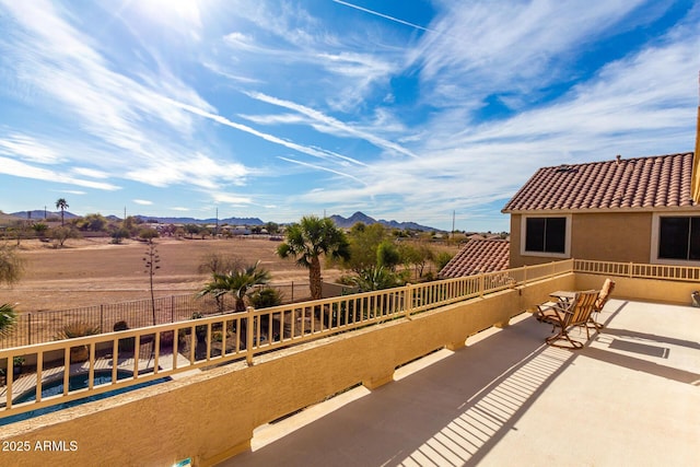 view of patio with a mountain view and fence