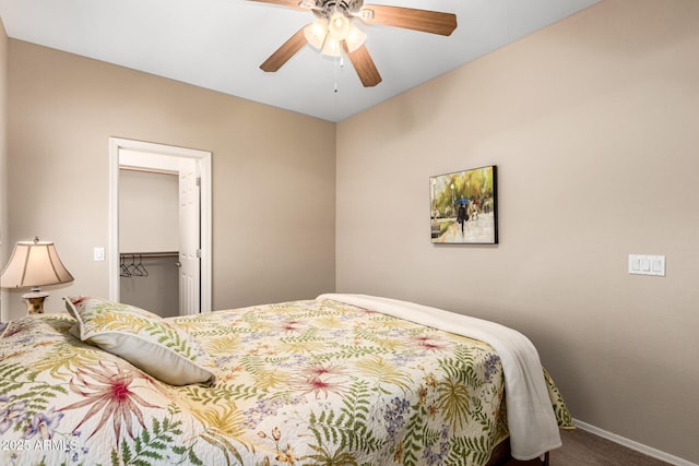 bedroom featuring baseboards, ceiling fan, a spacious closet, carpet flooring, and a closet