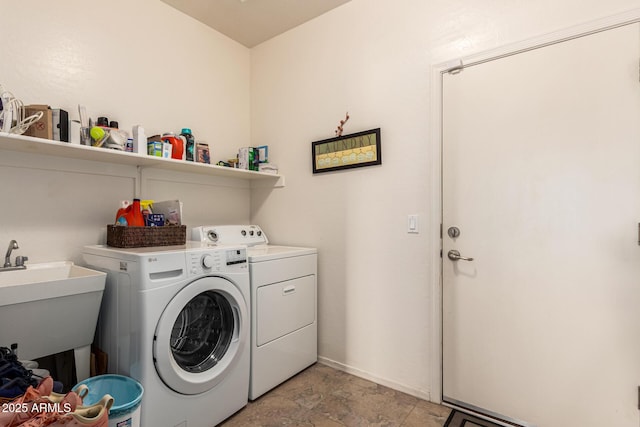 laundry room with washing machine and dryer, laundry area, a sink, and baseboards