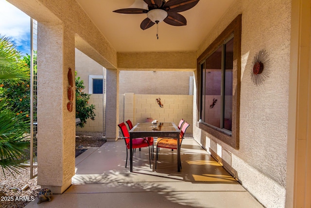 view of patio with outdoor dining area, ceiling fan, and fence