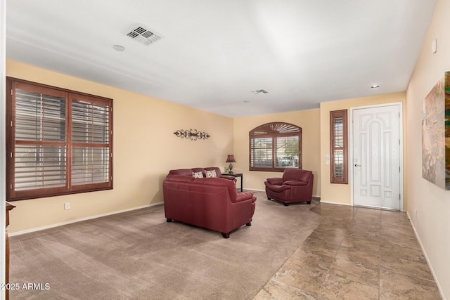 carpeted living room featuring visible vents and baseboards