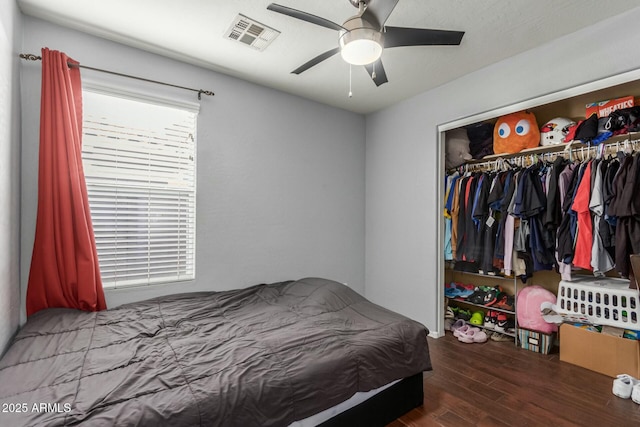 bedroom featuring a closet, visible vents, ceiling fan, and wood finished floors