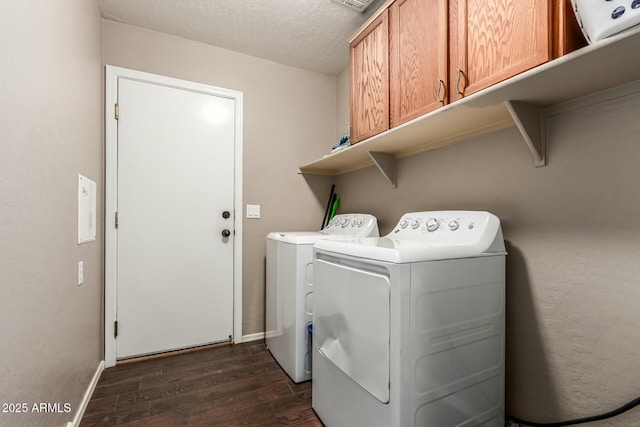 laundry room with dark wood-style flooring, washing machine and clothes dryer, cabinet space, a textured ceiling, and baseboards