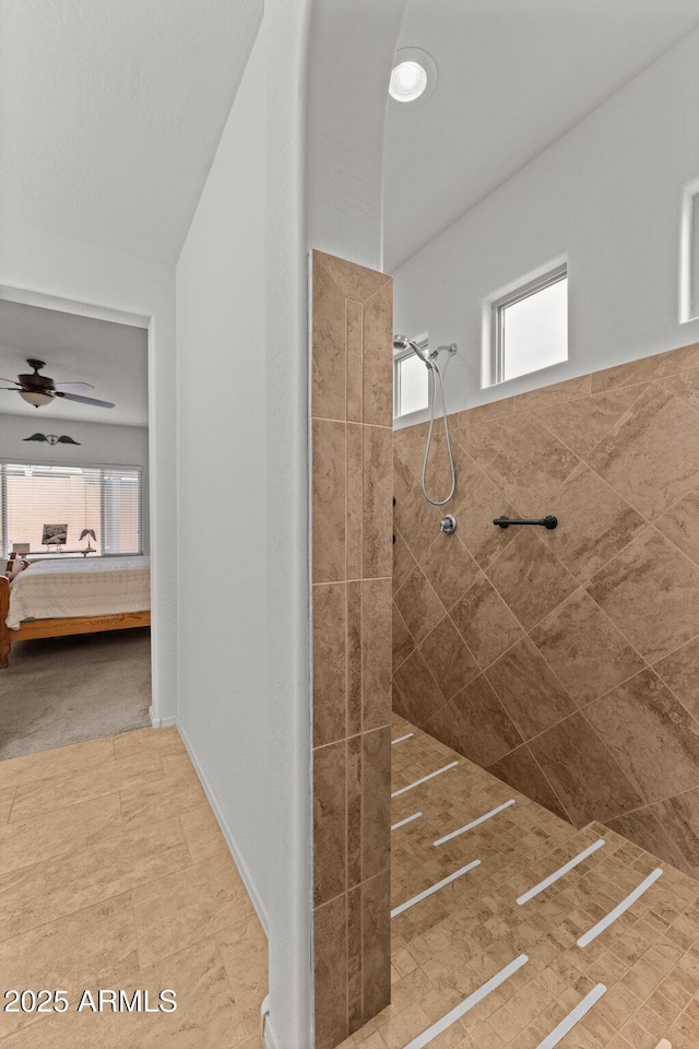 bathroom with tiled shower, a wealth of natural light, and ceiling fan