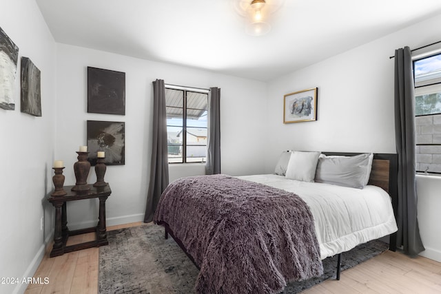 bedroom with light hardwood / wood-style flooring and multiple windows