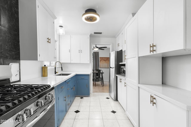 kitchen featuring appliances with stainless steel finishes, blue cabinetry, sink, and white cabinetry