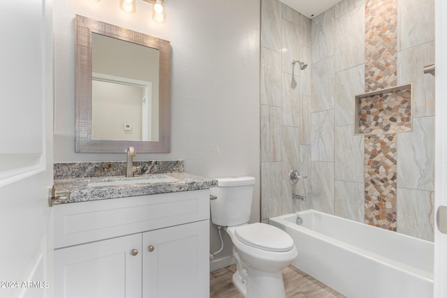 full bathroom featuring wood-type flooring, tiled shower / bath combo, vanity, and toilet