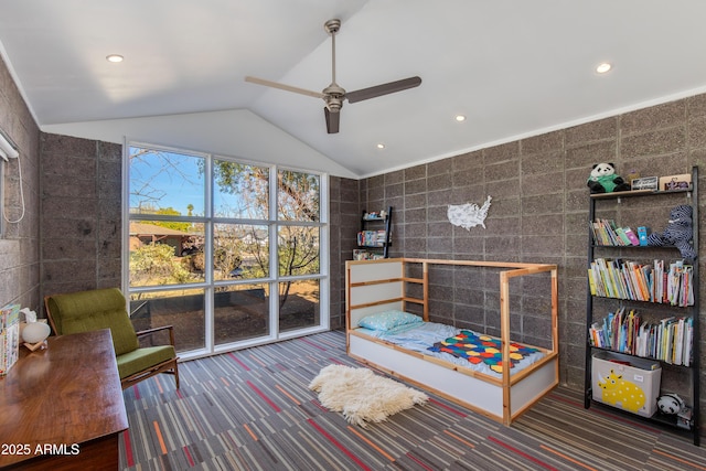 interior space with ceiling fan, carpet flooring, vaulted ceiling, and tile walls