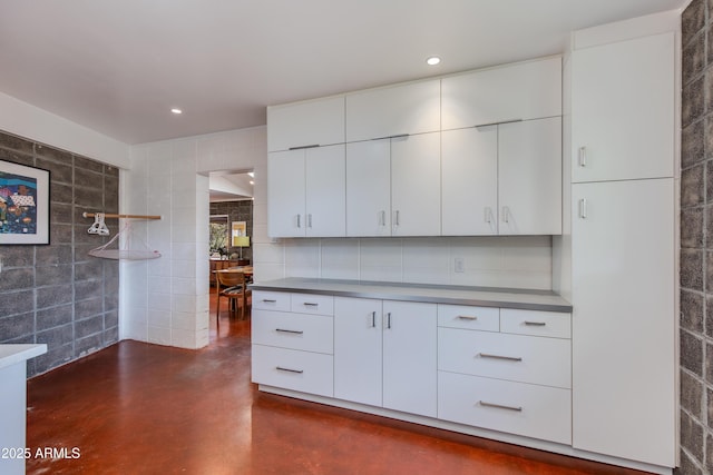 kitchen featuring tile walls and white cabinets