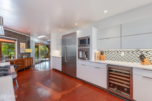 kitchen featuring white cabinetry, built in appliances, wine cooler, and decorative backsplash