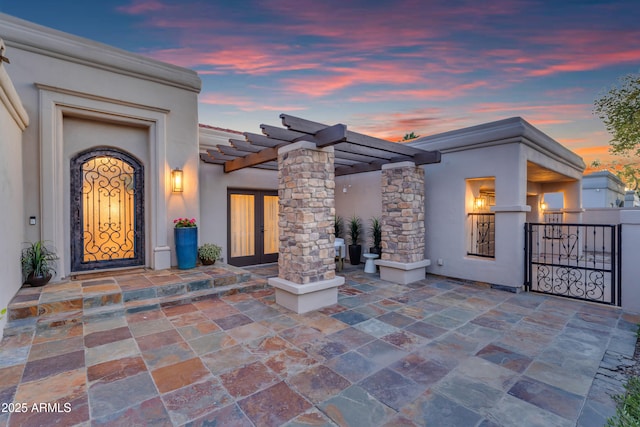 patio terrace at dusk with a gate and a pergola