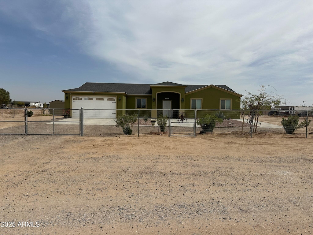 view of front of property with driveway, an attached garage, fence, and a gate