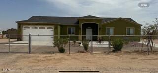 ranch-style home featuring a garage and fence